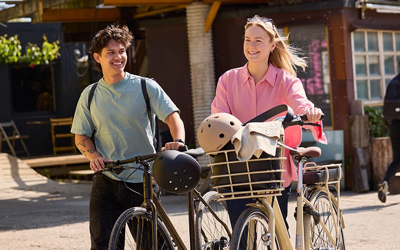 En Pige Der Kommer Gående Med En Klassisk Elcykel Og En Dreng Der Går Med En Citybike