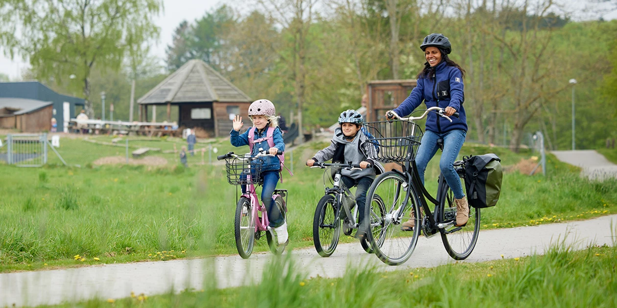 En Pige Og En Dreng På Børnecykel Og En Dame På Citybike