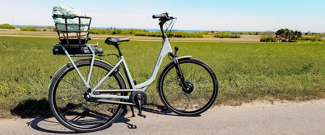 En elcykel med oppakning der står i den danske natur